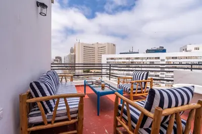 a balcony with chairs and a table and buildings at Assayag Art Deco - 1930 in Casablanca