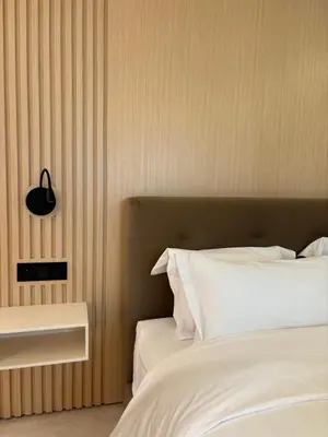a bedroom with a white bed and a black clock on the wall at LabelCapitale in Rabat
