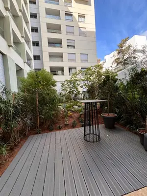 a wooden deck with a table in front of a building at LabelCapitale in Rabat