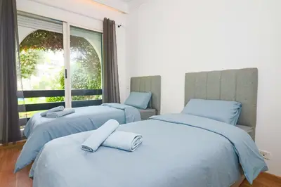 two beds in a room with a window at Lagoon Garden - 2 chambres proche Plage avec Piscine in Skhirat