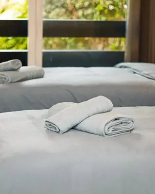 three white towels sitting on top of two beds at Lagoon Garden - 2 chambres proche Plage avec Piscine in Skhirat