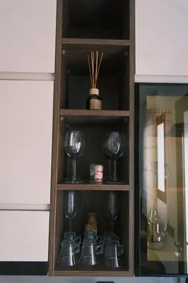 a wooden wine cabinet with wine glasses in it at Luxury Warm-Wood Duplex - Rooftop Sky Pool Access in Casablanca
