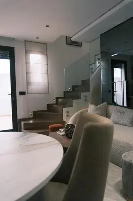 a living room with a couch and a table at Luxury Warm-Wood Duplex - Rooftop Sky Pool Access in Casablanca