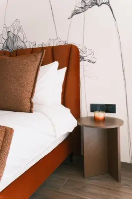 a bed with a wooden headboard and a side table at Luxury Warm-Wood Duplex - Rooftop Sky Pool Access in Casablanca