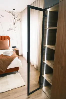 a bedroom with a glass closet with a bed at Luxury Warm-Wood Duplex - Rooftop Sky Pool Access in Casablanca