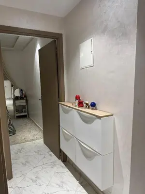 a white kitchen with a counter and a room at Appartement abwab tamaris in Dar Mouddene