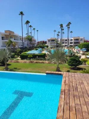 a swimming pool at a resort with palm trees at Superbe appartement de 3 chambres avec piscines in Tamaris