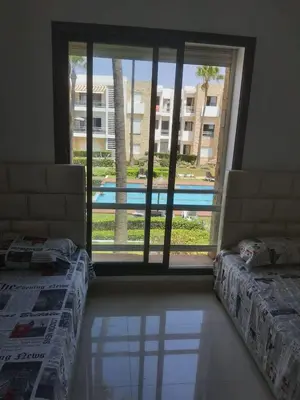 a room with two beds and a view of a pool at Superbe appartement de 3 chambres avec piscines in Tamaris