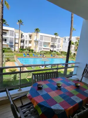 a table on a balcony with a view of a pool at Superbe appartement de 3 chambres avec piscines in Tamaris