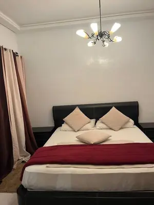 a bedroom with a bed with a chandelier above it at Superbe appartement de 3 chambres avec piscines in Tamaris