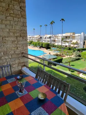 a table on a balcony with a view of a pool at Superbe appartement de 3 chambres avec piscines in Tamaris