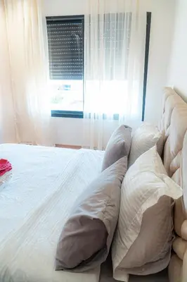 a bedroom with a bed with pillows and a window at cozy appartement, convenient local in Casablanca