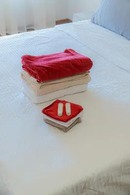 a pile of towels sitting on top of a bed at cozy appartement, convenient local in Casablanca