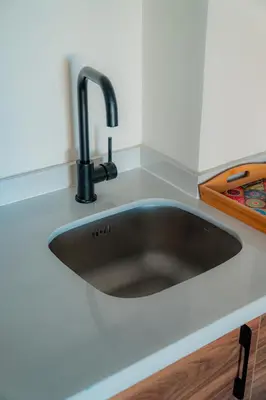 a kitchen sink with a black faucet on a counter at cozy appartement, convenient local in Casablanca