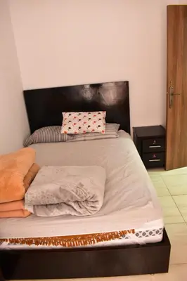 a large bed with a wooden headboard in a bedroom at Havre de paix appartement in Mohammedia
