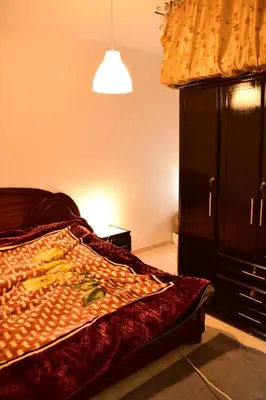 a bedroom with a bed and a black cabinet at Havre de paix appartement in Mohammedia