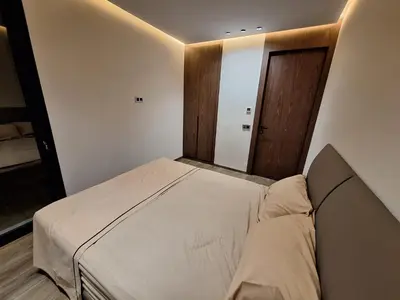 a small bedroom with a bed and a wooden door at Appartement to stay in Casablanca, CfC in Casablanca
