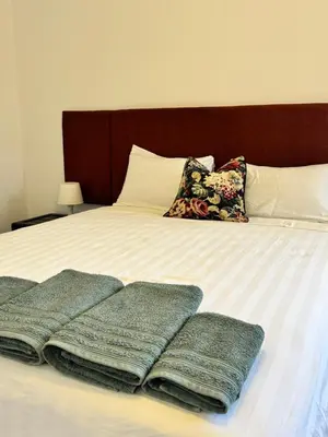 a bed with four pillows and blankets on it at Stylish 2BR in Central Rabat with Panoramic View in Rabat
