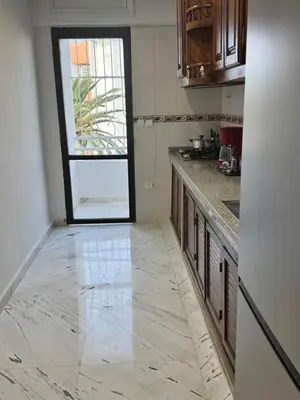 a kitchen with a marble floor and a window at Stylish 2BR in Central Rabat with Panoramic View in Rabat