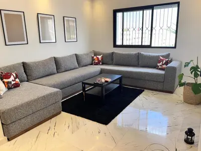 a living room with a couch and a table at Stylish 2BR in Central Rabat with Panoramic View in Rabat