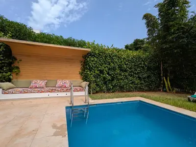 a swimming pool with a couch next to a hedge at Villa 3-bedroom with Private Pool in Tamaris in Tamaris