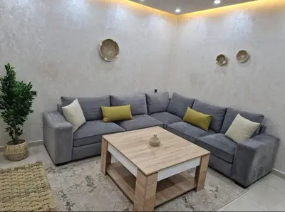 a living room with a blue couch and a coffee table at Appartement bien meublé in Rabat