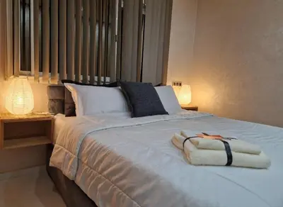 a white bed with two towels on top of it at Appartement bien meublé in Rabat
