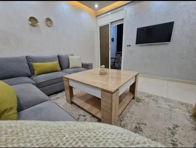 a living room with a couch and a table at Appartement bien meublé in Rabat
