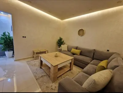 a living room with a couch and a table at Appartement bien meublé in Rabat