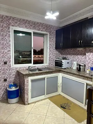 a kitchen with a counter with a microwave and a window at Réservez dès maintenant Calme confort et proximité in Oulad Mbark