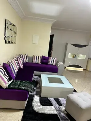 a living room with a purple couch and a table at Réservez dès maintenant Calme confort et proximité in Oulad Mbark