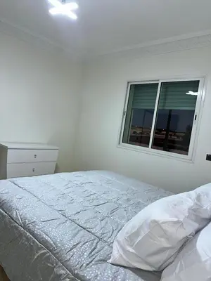 a white bedroom with a bed and a window at Réservez dès maintenant Calme confort et proximité in Oulad Mbark