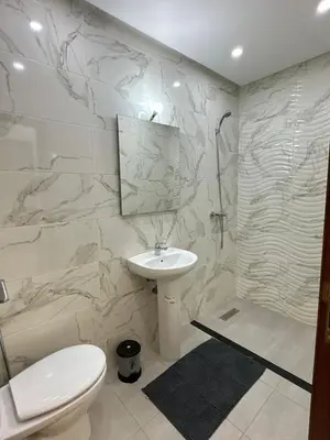 a white bathroom with a sink and a toilet at appartement meublé temara in Temara