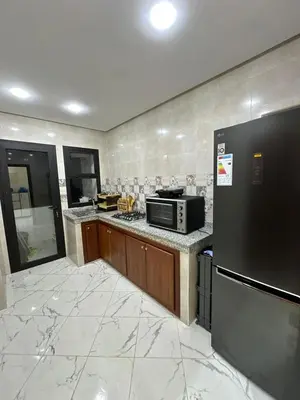a kitchen with a stove and a microwave at appartement meublé temara in Temara