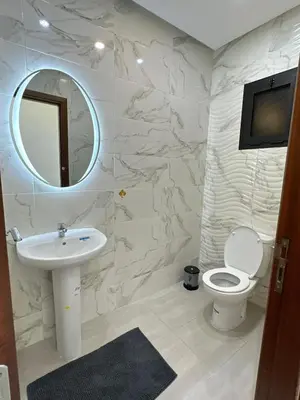 a bathroom with a sink and a toilet and a mirror at appartement meublé temara in Temara