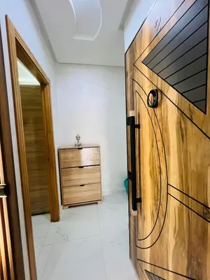 a room with a wooden door and a dresser at Modern Apartment Bouznika in Bouznika
