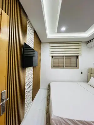 a bedroom with a bed and a tv on a wall at Modern Apartment Bouznika in Bouznika