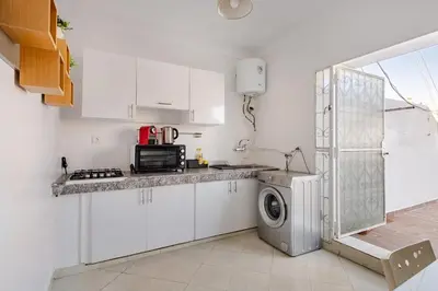 a kitchen with white cabinets and a washing machine at Modern 1 Bedroom W Terrace-Arribat Center in Rabat