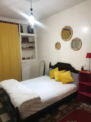 a bedroom with a large bed with yellow pillows at Appartement meublé Centre de Témara in Temara