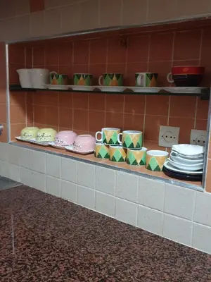 a shelf filled with plates and cups on a wall at Appartement meublé Centre de Témara in Temara