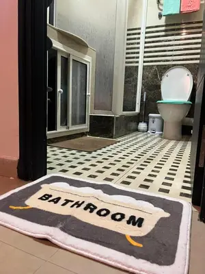 a bathroom with a toilet and a rug on the floor at Appartement meublé Centre de Témara in Temara