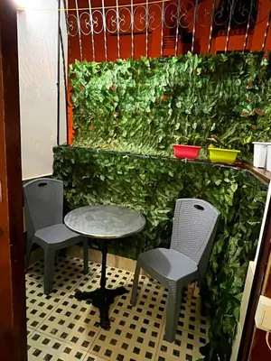 a green wall with three chairs and a table at Appartement meublé Centre de Témara in Temara