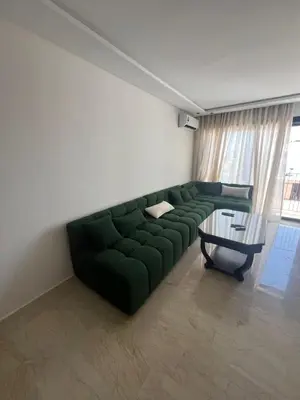 a living room with a green couch and a table at Adam résidence in Casablanca