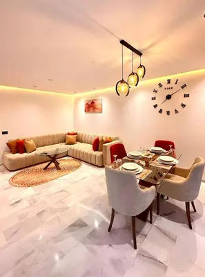 a living room with a couch and a table and a clock at Cozy Studio Steps from Med V Stadium in Casablanca
