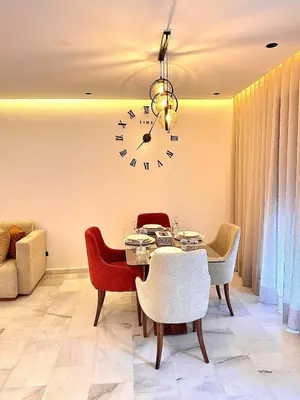 a dining room with a table and a clock on the wall at Cozy Studio Steps from Med V Stadium in Casablanca