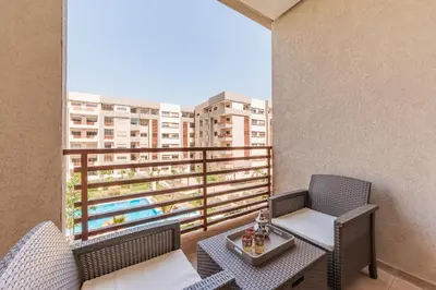 a balcony with two chairs and a table on a balcony at L'Horizon - 1 BR - Pool & Terrace in Nouaseur