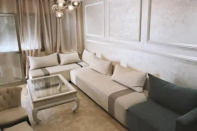 a living room with two couches and a coffee table at Modern apartment with pool parking in O Ben Slimane