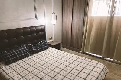 a bedroom with a bed with a black headboard at Modern apartment with pool parking in O Ben Slimane