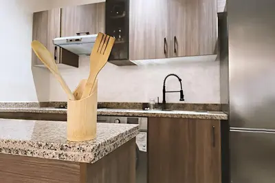 a kitchen with a counter with wooden utensils at Modern apartment with pool parking in O Ben Slimane