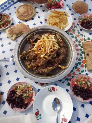 a table with a pot of food and plates of food at le Cabanon Beldi in Rabat